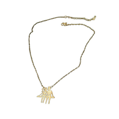 Gold-tone couple pendant necklace on white background